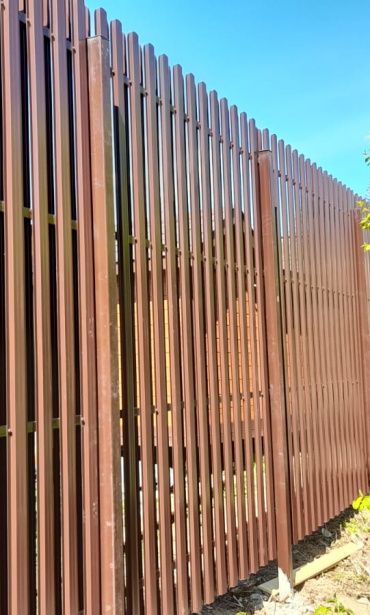 Высокий забор из металлического штакетника и профнастила